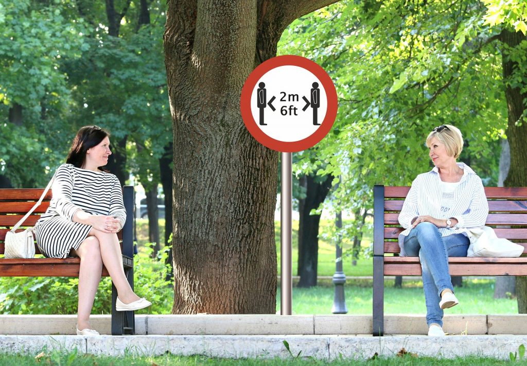 Ladies on benches demonstrating correct social distancing