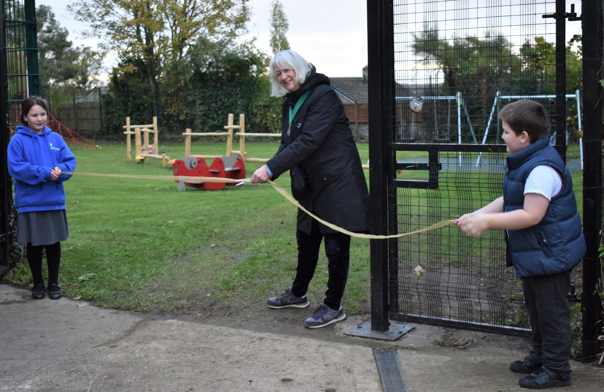 Cllr Liz Duncan cutting the ribbon, assisted by Rebecca and Bradley