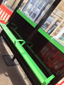 Green seats in a black bus shelter