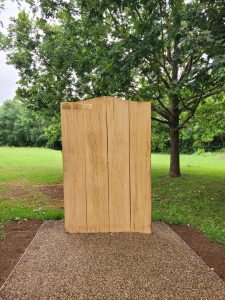 A wooden monolith bearing memorial plaques