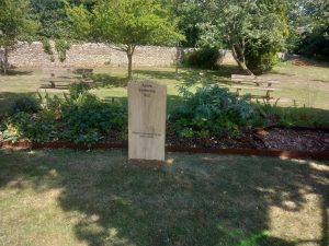 A flower bed with a large wooden sign