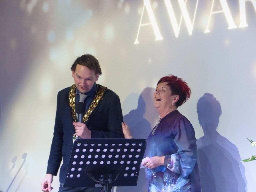Award winning woman on stage with the Mayor