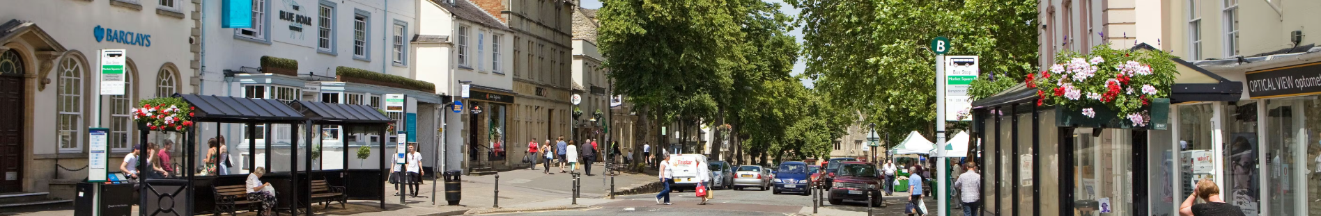 panoramic photograph of Witney High St with shops, bus shelters and pedestrians